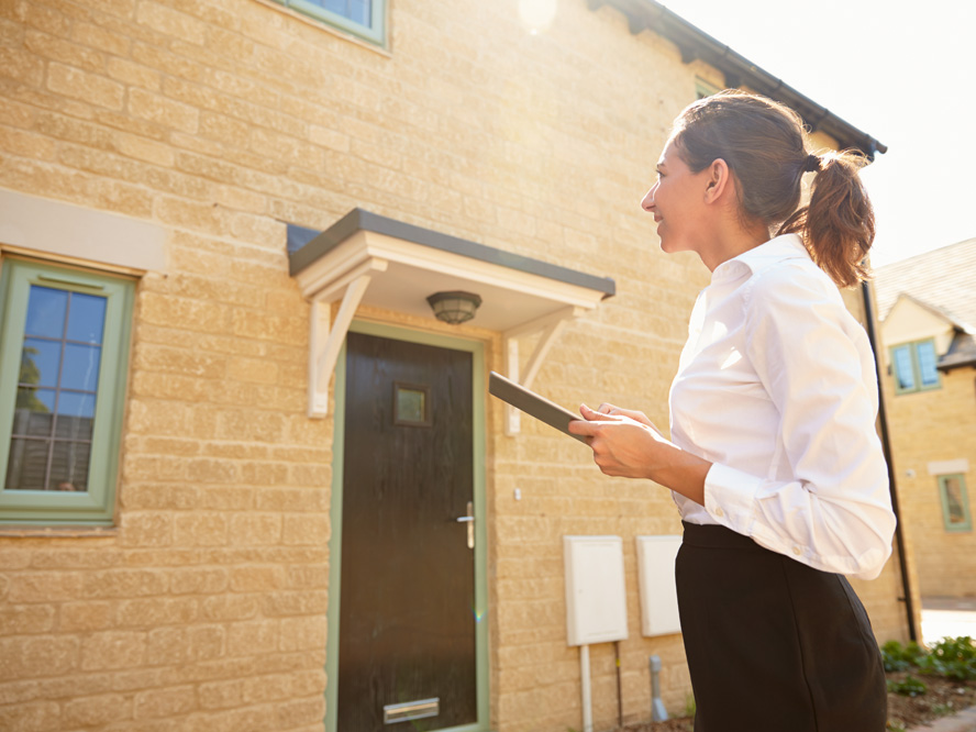 Surveyor stood outside a house